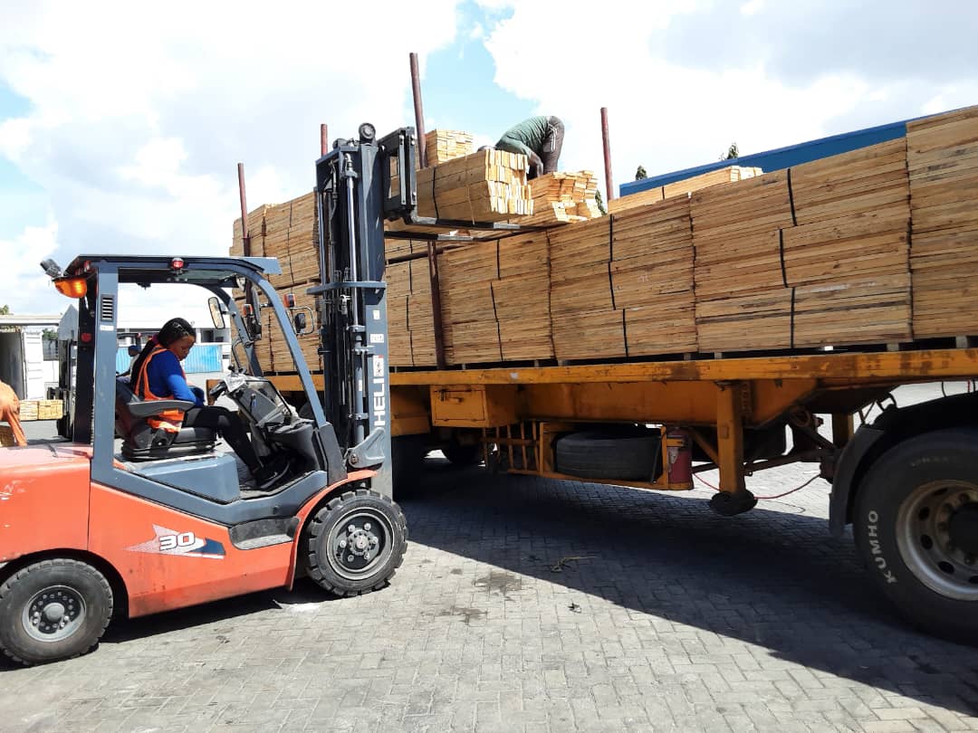 pine_pallet_wood_from_the_company_Mufindi_wood_plantation_and_industries_ltd_being_unloaded_in_a_car_to_be_loaded_into_a_container_to_go_abroad