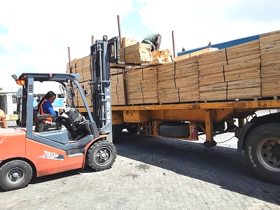 pine_pallet_wood_from_the_company_Mufindi_wood_plantation_and_industries_ltd_being_unloaded_in_a_car_to_be_loaded_into_a_container_to_go_abroad